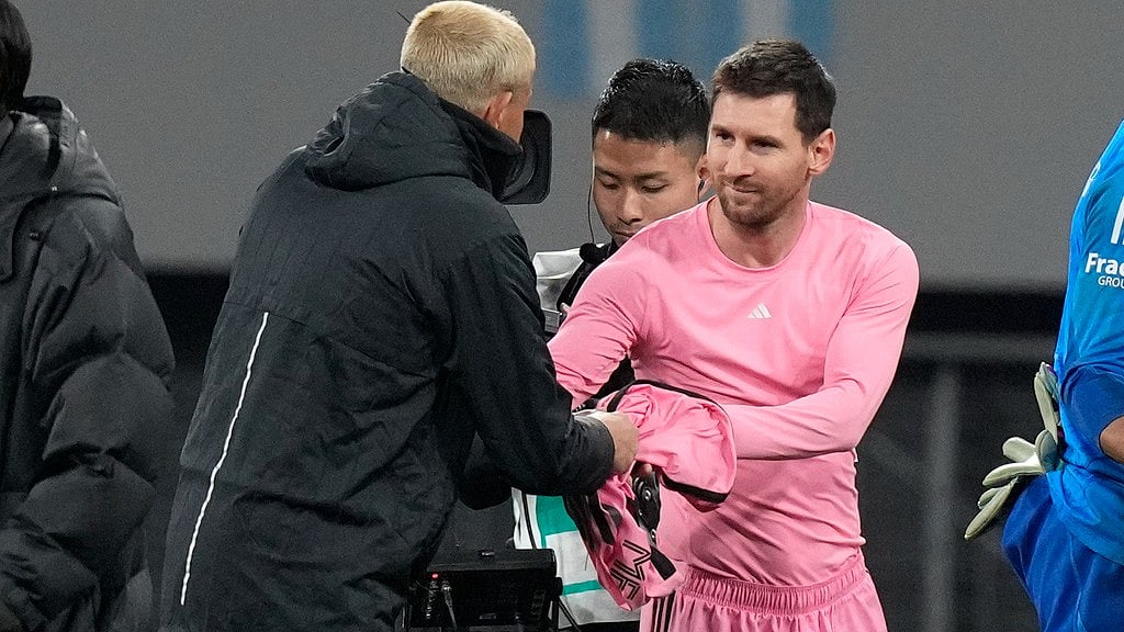 (AP Photo/Eugene Hoshiko) : Inter Miami's Lionel Messi, right gives his jersey to a Vissel Kobe's official after their friendly soccer match at the National Stadium, Wednesday, Feb. 7, 2024, in Tokyo, Japan. 