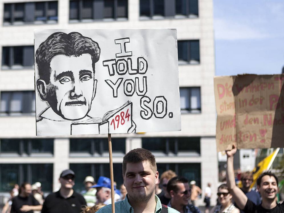 Photo via Getty : Protestor holding up a banner during a demonstration in the city center of Frankfurt, Germany. 