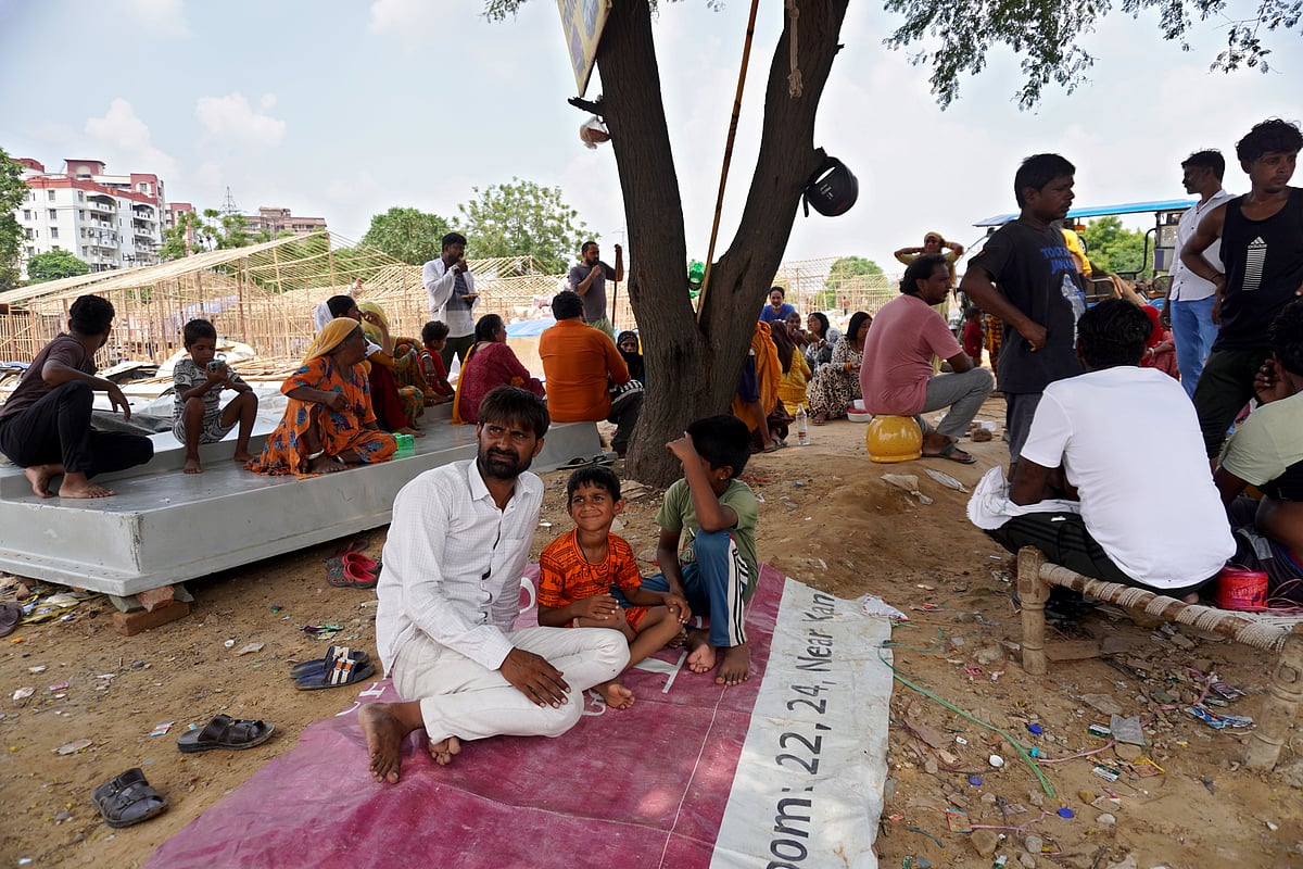 Mayank Makhija/Outlook : Residents of Gadia Lohar seek refuge under a tree at the partially demolished site of Gurugrams well-known Banjara Market