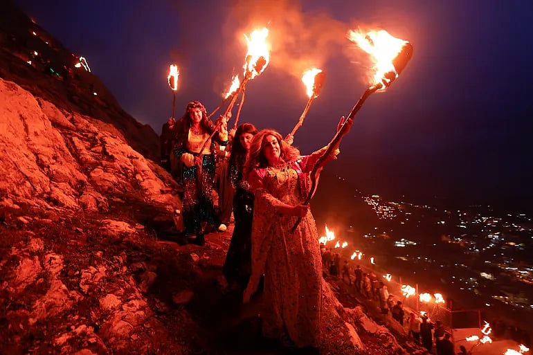 Iraqi Kurdish people carry fire torches, as they celebrate Nowruz