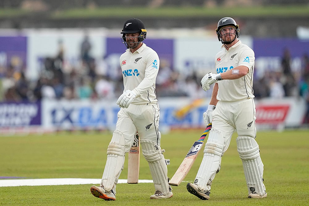 | Photo: AP/Eranga Jayawardena : Sri Lanka Vs New Zealand 2nd Test: New Zealands Glenn Phillips and Tom Blundell leave the filed after the play interrupted due to bad light