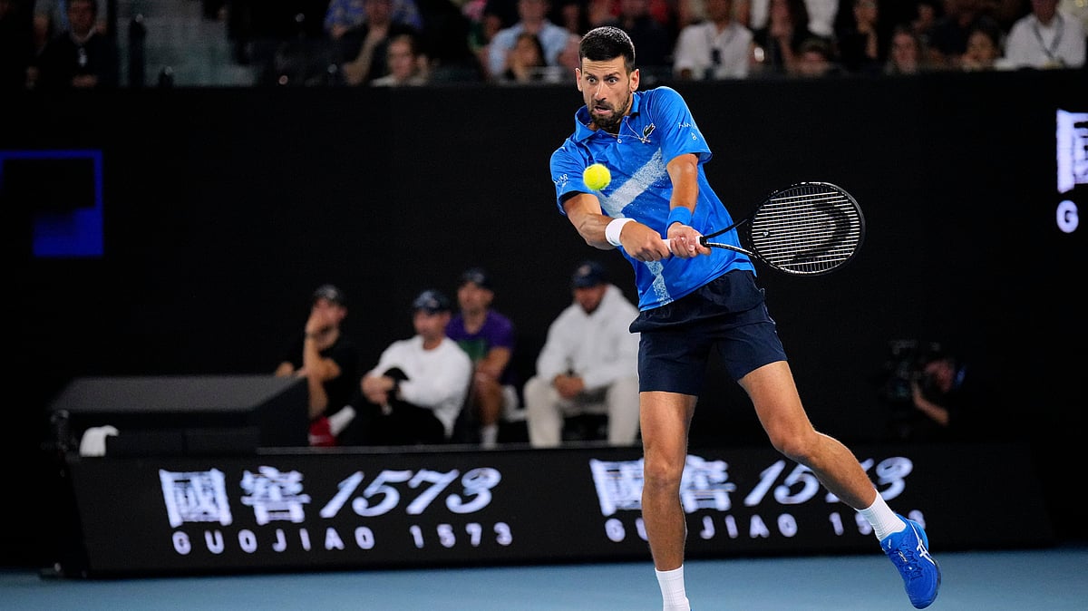 (AP Photo/Vincent Thian) : Novak Djokovic of Serbia plays a backhand return to Carlos Alcaraz of Spain during their quarterfinal match at the Australian Open tennis championship in Melbourne, Australia, Tuesday, Jan. 21, 2025. 