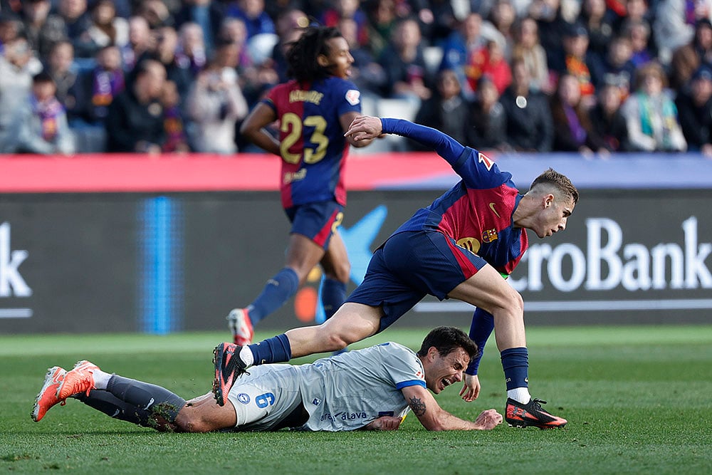 | Photo: AP/Joan Monfort : La Liga 2024-25: Alaves' Ander Guevara, falls by Barcelona's Fermin Lopez
