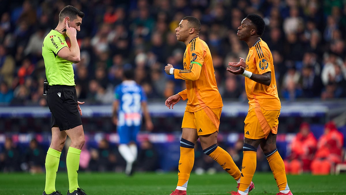 Real Madrid stars Vinicius Junior and Kylian Mbappe approach referee Alejandro Muniz Ruiz