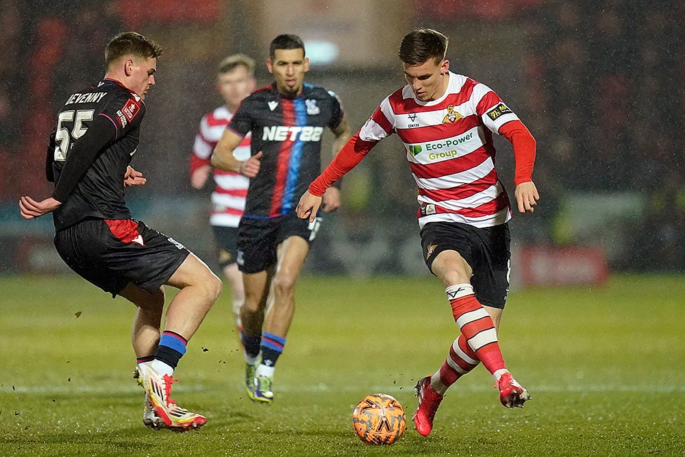 | Photo: Danny Lawson/PA via AP : FA Cup Fourth Round: Crystal Palace's Justin Devenny and Doncaster Rovers' George Broadbent challenge for the ball 