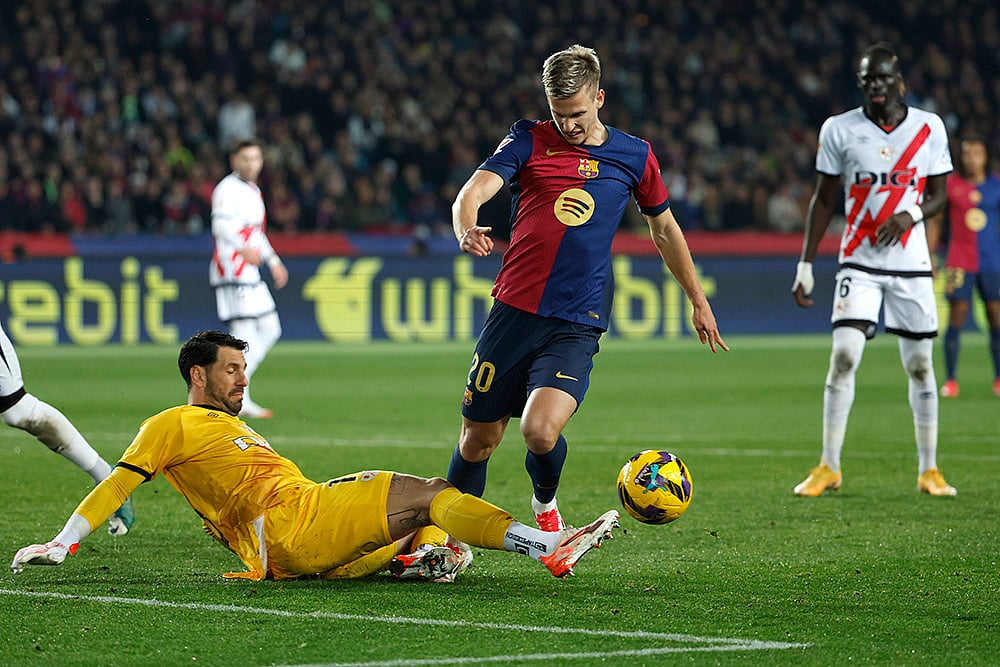 | Photo: AP/Joan Monfort : La Liga 2024-25: Barcelona's Dani Olmo, centre, challenges for the ball with Rayo's goalkeeper Augusto Batalla