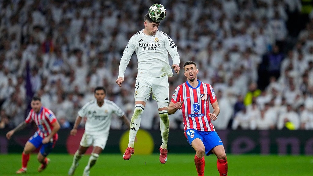 Photo: AP : Real Madrid's Federico Valverde heads the ball past Atletico Madrid's Clement Lenglet 