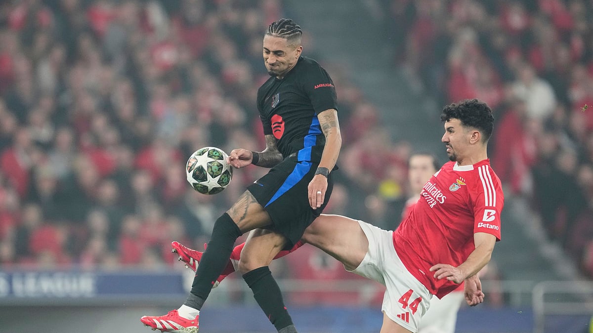 (AP Photo/Armando Franca) : Barcelona's Raphinha, left, is challenged by Benfica's Tomas Araujo during the Champions League round of 16 first leg soccer match between SL Benfica and FC Barcelona at the Luz stadium in Lisbon, Wednesday, March 5, 2025. 
