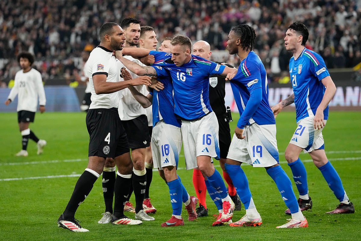 (AP Photo/Martin Meissner) : Italy's Davide Frattesi, centre, Destiny Udogie, second from right, and Nicolo Barella, centre left, argue with Germany's Jonathan Tah, left, during the Nations League quarterfinal second leg soccer match between Germany and Italy at the Signal-Iduna Park in Dortmund, Germany, Sunday, March 23, 2025. 