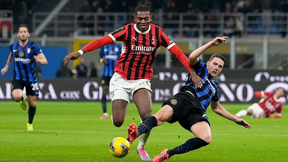| Photo: AP/Antonio Calanni : Serie A 2024-25: Inter Milan's Benjamin Pavard tries to tackle AC Milan's Rafael Leao