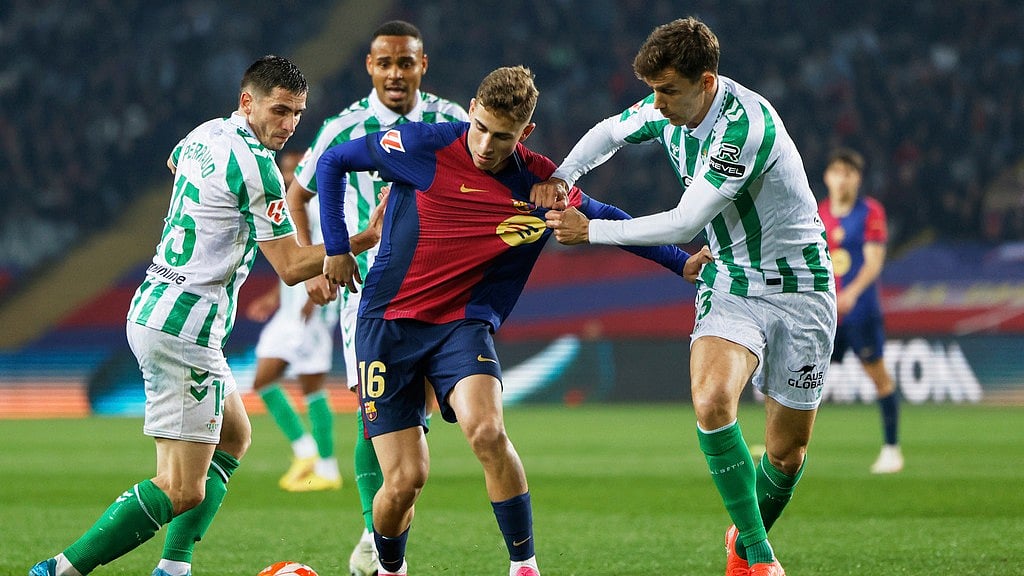 Photo: AP : Barcelona's Fermin Lopez, centre, is challenged by Real Betis' Romain Perraud, left, and Diego Llorente during their La Liga match.