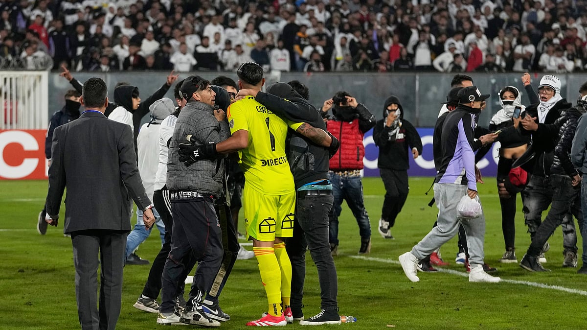 AP Photo/Esteban Felix : Goalkeeper Brayan Cortes of Chile's Colo Colo confronts fans who invaded the field during their Copa Libertadores 2025, Group E match against Brazil's Fortaleza at the Monumental Stadium in Santiago, Chile on April 10, 2025.