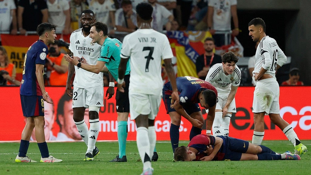 AP : Referee Ricardo De Burgos Bengoetxea, third right, speaks with Barcelona's Pedri during the Spanish Copa del Rey final soccer match between Barcelona and Real Madrid at Estadio de La Cartuja stadium.