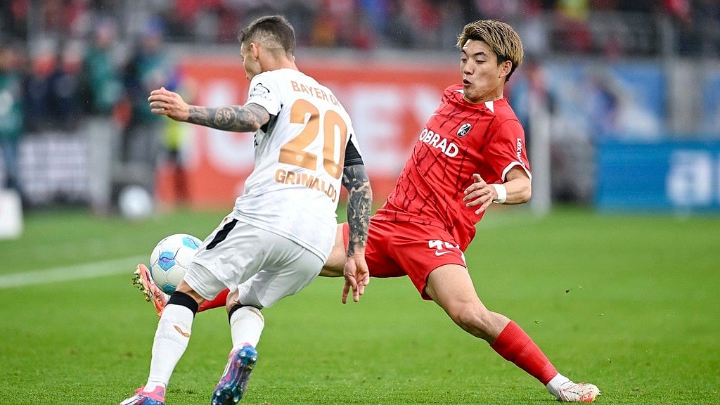 AP : Bayer Leverkusen's Alejandro Grimaldo, left, vies for the ball with Freiburg's Ritsu Doan, during the German Bundesliga match.