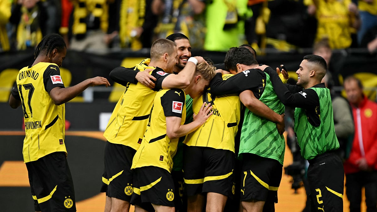 Borussia Dortmund's players mob Felix Nmecha after he makes it 3-0.