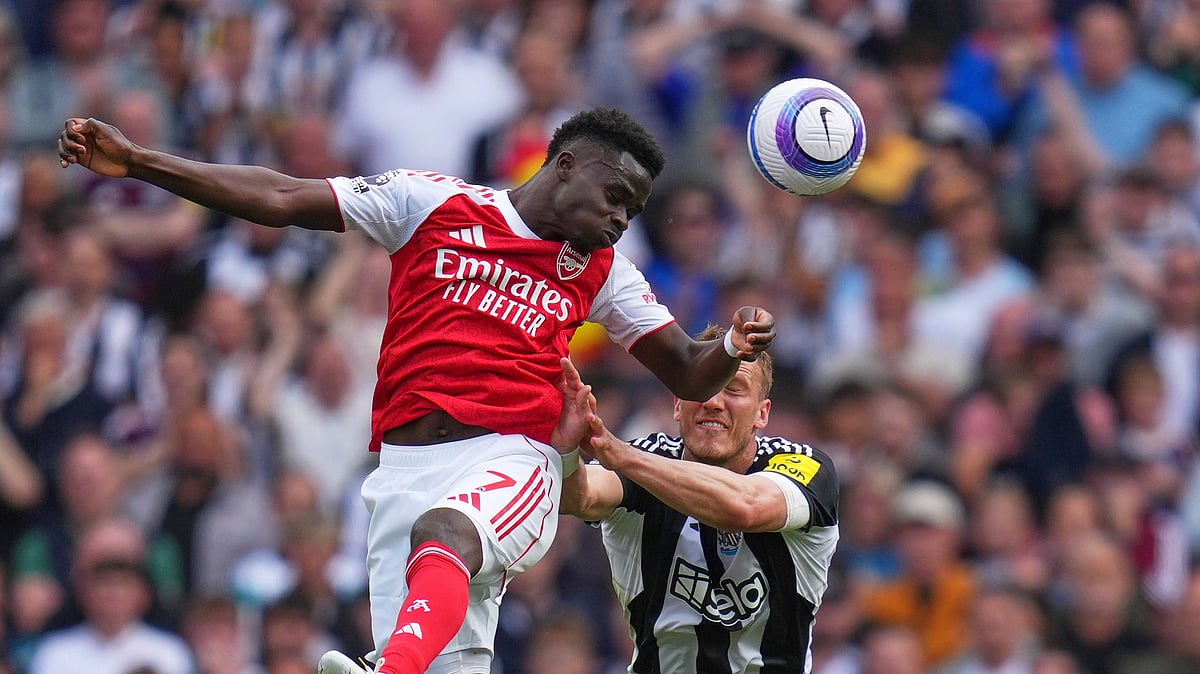 AP Photo/Kirsty Wigglesworth : Arsenal's Bukayo Saka, left, challenges for the ball with Newcastle's Dan Burn during the English Premier League football match between Arsenal and Newcastle United at Emirates stadium in London.
