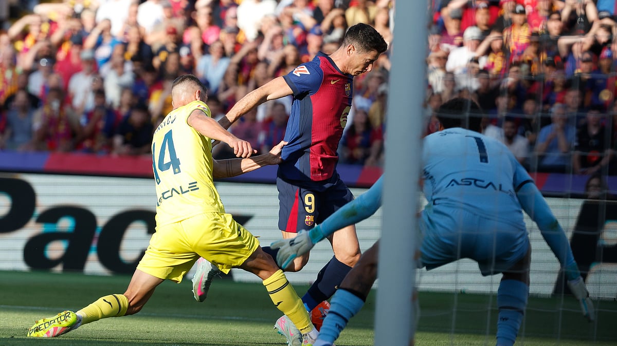 (AP Photo/Joan Monfort) : Barcelona's Robert Lewandowski, centre, challenges for the ball with Villarreal's Santi Comesana during the Spanish La Liga soccer match between Barcelona and Villarreal at Lluis Companys Olympic Stadium in Barcelona, Spain, Sunday, May 18, 2025.