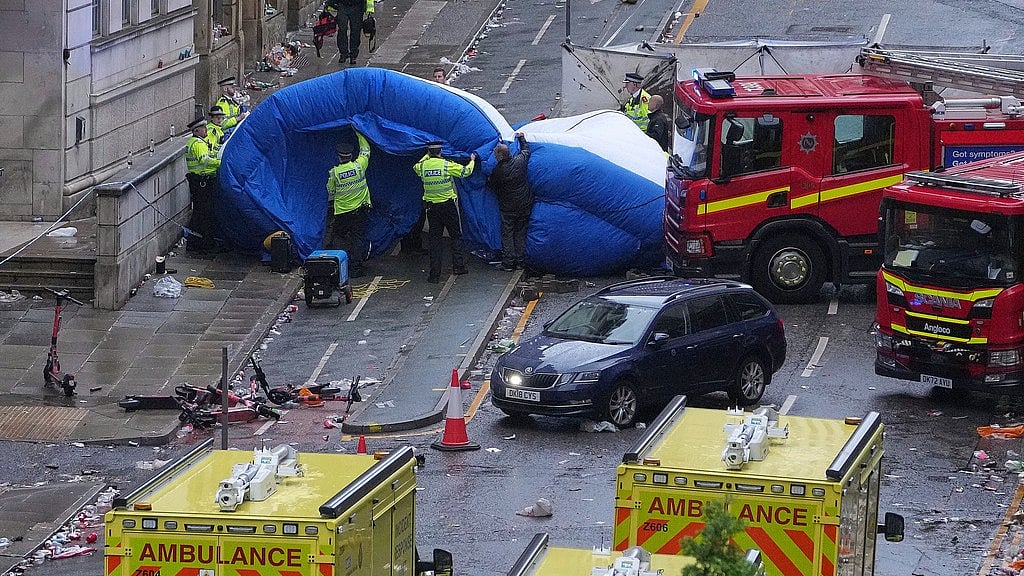 AP/Jon Super : Police and emergency personnel deal with an incident after a car collided with pedestrians near the Liver Building during the Premier League winners parade in Liverpool, England, Monday, May 26, 2025