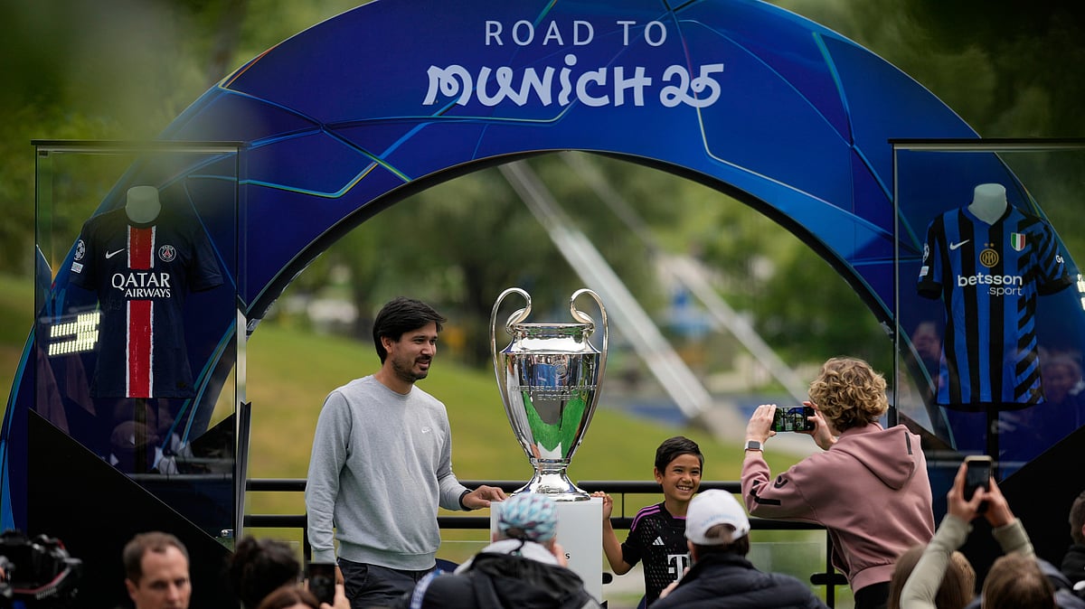 | Photo: AP/Matthias Schrader : People take pictures with the trophy during the opening of the official UEFA fan festival in Munich, Germany, Thursday, May 29, 2025, ahead of the Champions League final soccer match between Inter and PSG.