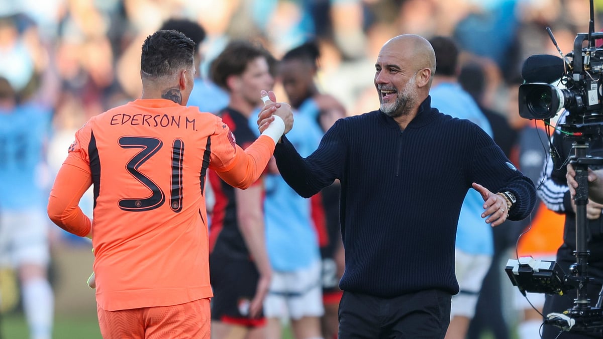Manchester City goalkeeper Ederson and manager Pep Guardiola having a chat mid-game.