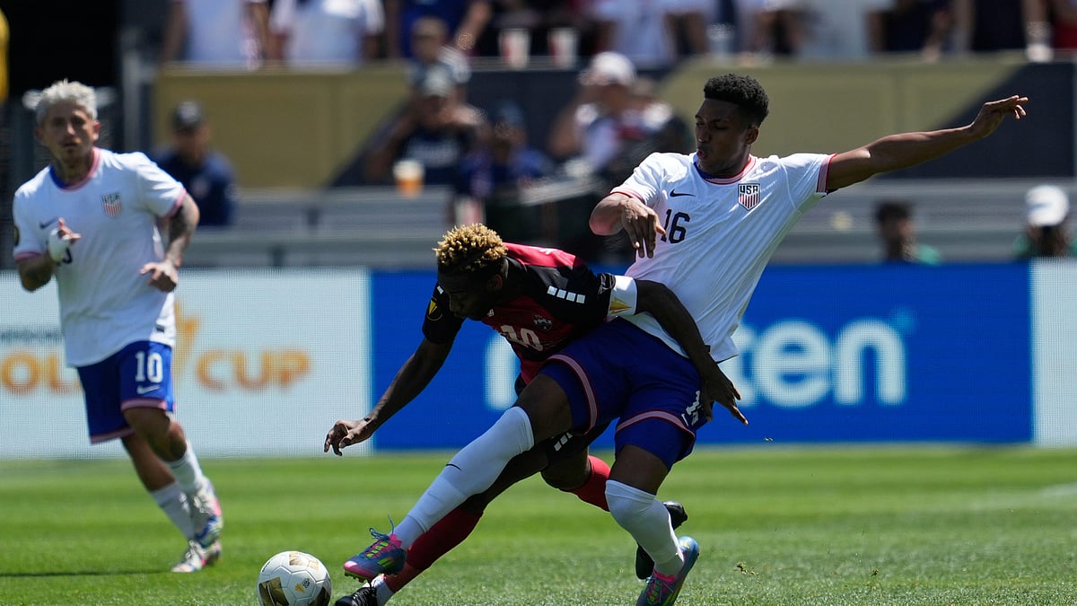 AP Photo/Jeff Chiu : Trinidad and Tobago midfielder Kevin Molino, foreground left, runs toward the ball against United States defender Alexander Freeman (16) during the first half of a CONCACAF Gold Cup football match in San Jose, California.