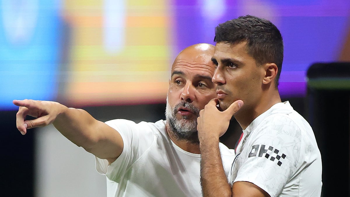 Manchester City manager Pep Guardiola with midfielder Rodri