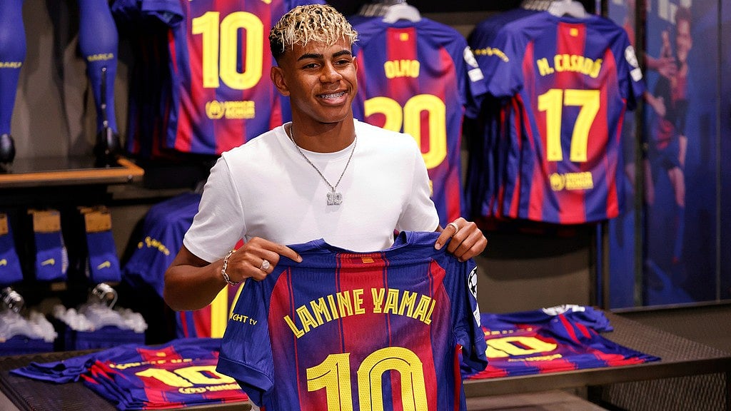  (AP Photo/Joan Monfort) : FC Barcelona player Lamine Yamal poses with his new jersey after signing a contract extension with the soccer club in Barcelona, northern Spain, Wednesday, July 16, 2025.