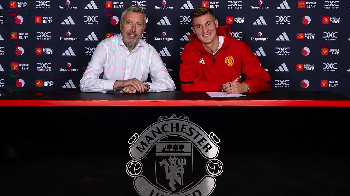 Benjamin Sesko (right) signs his Manchester United contract with director of football Jason Wilcox (left)