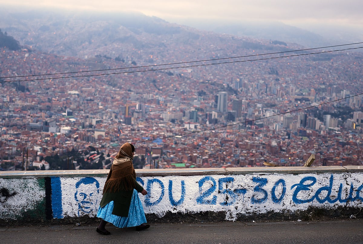 (AP Photo/Juan Karita) : A woman walks past campaign murals for presidential candidates prior to Sundays presidential and legislative elections in El Alto, Bolivia, Thursday morning, Aug. 14, 2025. 
