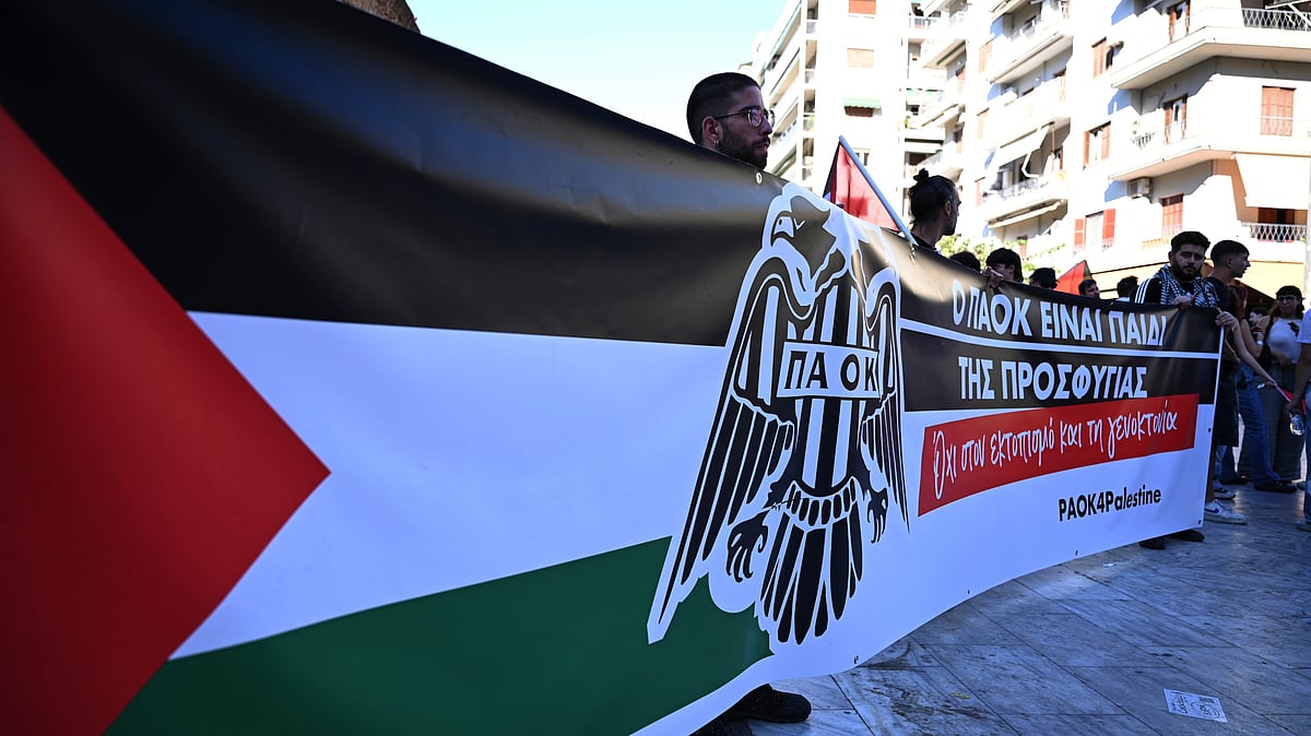 | Photo: AP/Giannis Papanikos : Pro-Palestinian protesters, most of them PAOK fans, hold a banner that reads "PAOK is the child of refugees. No to displacement and genocide" as they gather ahead of a Europa League soccer match between PAOK and Israeli team Maccabi Tel Aviv in the port city of Thessaloniki, northern Greece, Wednesday, Sept. 24, 2025.