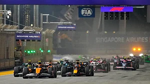 File/AP : McLaren driver Lando Norris of Britain leads the field into turn one at the start of the Singapore Formula One Grand Prix at the Marina Bay Street Circuit.