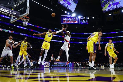 | Photo: AP/Ethan Swope : Los Angeles Lakers forward Rui Hachimura (28) blocks the ball against Portland Trail Blazers guard Jrue Holiday (5) during the second half of an NBA basketball game in Los Angeles.