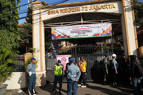 . (AP Photo/Dita Alangkara) : Police officers and military personnel stand guard at the gate of a school where explosions reportedly occurred, in Jakarta, Indonesia, Friday, Nov. 7, 2025