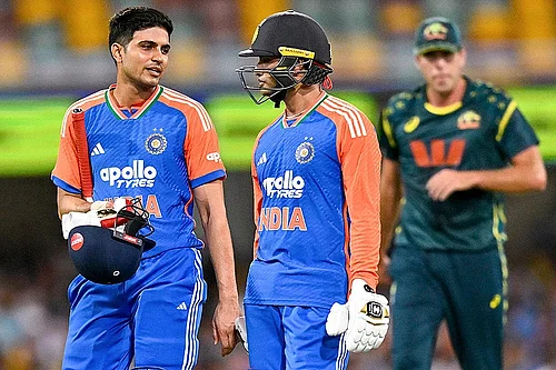 Photo: PTI/Izhar Khan : Indias Shubman Gill, left, and Abhishek Sharma return to pavilion as rain stops play during the fifth T20I cricket match of a series between India and Australia, in Brisbane.
