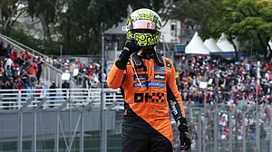 (AP Photo/Ettore Chiereguini) : McLaren driver Lando Norris of Britain celebrates after winning the Brazilian Formula One Grand Prix at the Interlagos race track, in Sao Paulo, Sunday, Nov. 9, 2025.