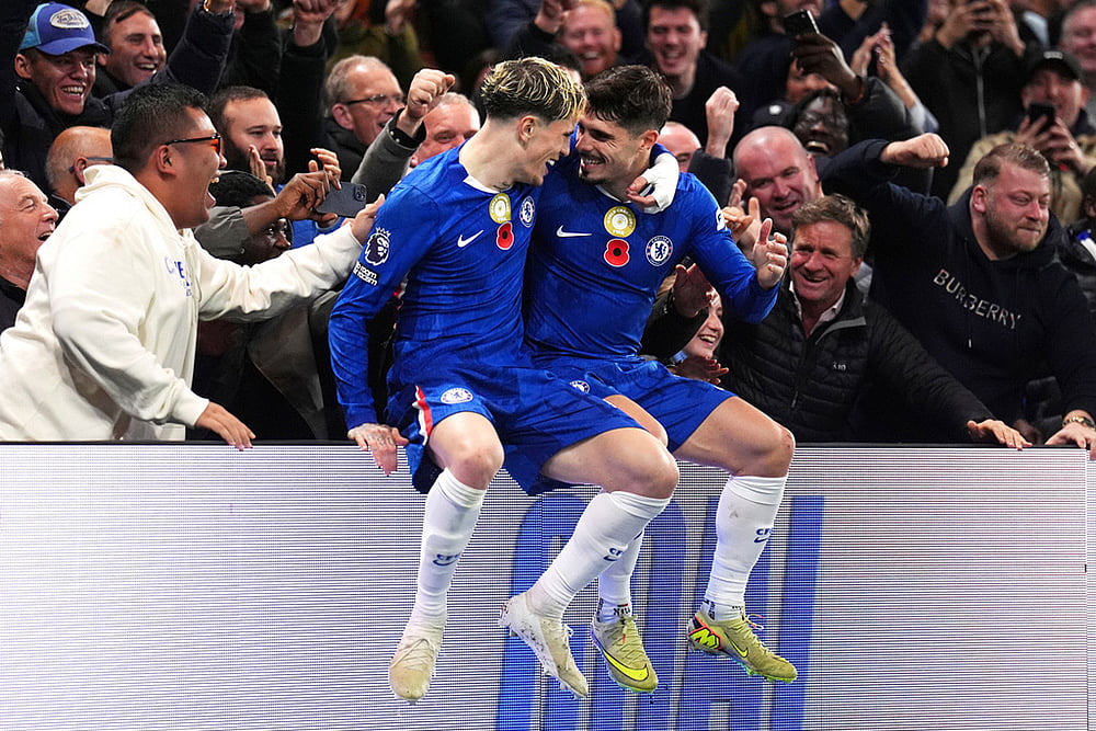 | Photo: John Walton/PA via AP : Chelsea's Pedro Neto, right, celebrates with teammate Alejandro Garnacho, left, in front of the fans after scoring a goal during the English Premier League soccer match against the Wolverhampton Wanderers in London.