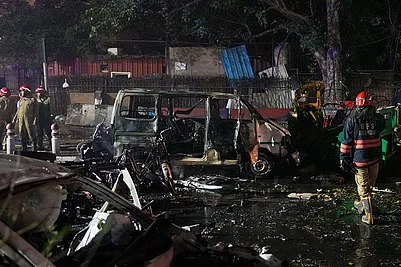 | Photo: PTI/Salman Ali : Firefighters at the spot after a blast occurred in a parked car near Red Fort, leaving multiple vehicles in flames, in New Delhi.
