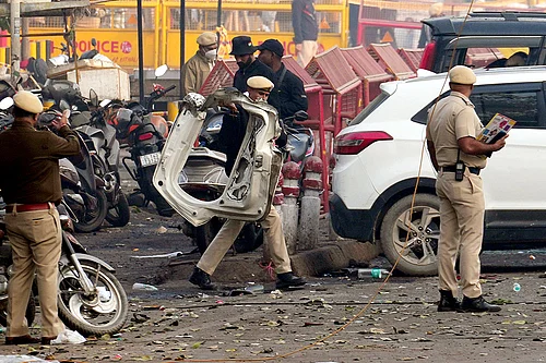 Photo: PTI/Kamal Kishore : Police personnel at the site in the aftermath of the blast that occurred near Red Fort Metro Station on Monday, killing at least nine people and gutting several vehicles, in New Delhi.