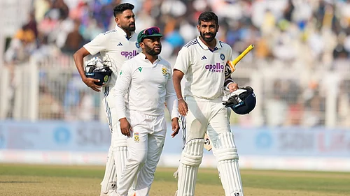 AP : Indias Jasprit Bumrah, right, and batting partner Mohammed Siraj, left, leave the field with South Africas captain Temba Bavuma at the end of the first Test in Kolkata.