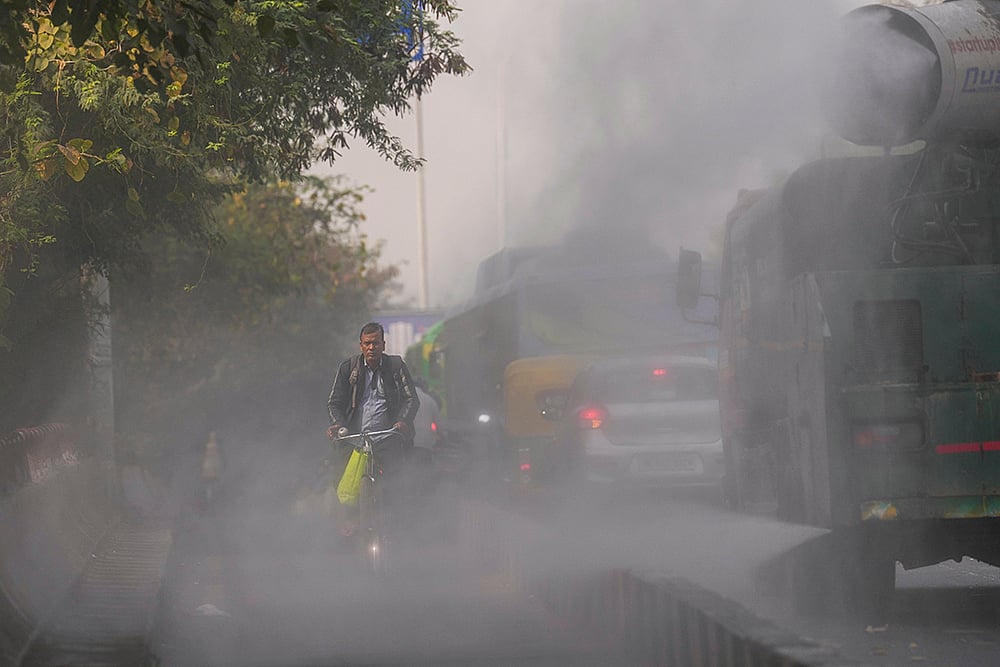 | Photo: PTI/Karma Bhutia : An anti-smog gun sprays water droplets to curb air pollution, in New Delhi.