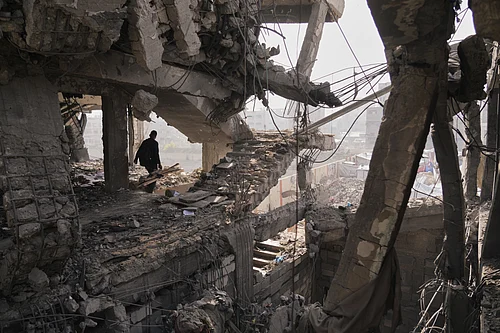 (AP Photo/Jehad Alshrafi) : A Palestinian walks through the ruins of a building damaged by an Israeli strike the day before, in Gaza City, Nov. 20, 2025.
