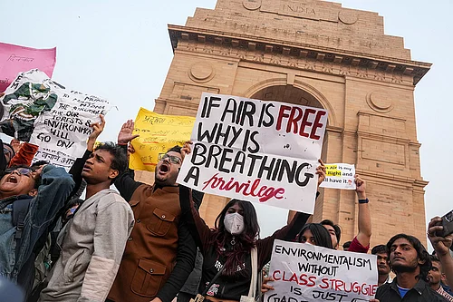 Photo: PTI/Karma Bhutia : People raise slogans during a protest against worsening air quality in the national capital, at the India Gate, in New Delhi. The air quality remained in the very poor category on Sunday morning, with the overall Air Quality Index (AQI) recorded at 381, according to the Central Pollution Control Board (CPCB).