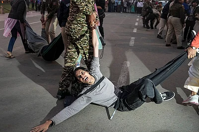 | Photo: PTI/Karma Bhutia : A protester being detained by security personnel during a protest against worsening air quality in the national capital, near the India Gate, in New Delhi. The air quality remained in the very poor category on Sunday morning, with the overall Air Quality Index (AQI) recorded at 381, according to the Central Pollution Control Board (CPCB).