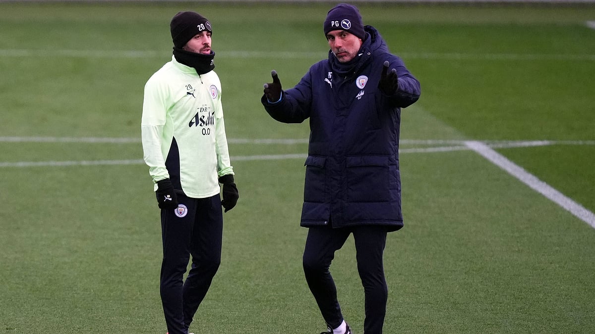 | Photo: PA/Mike Egerton via AP : Manchester City's manager Pep Guardiola talks with Bernardo Silva during a training session on November 24, 2025, ahead of the UEFA Chamoions League match against Bayer 04 Leverkusen.