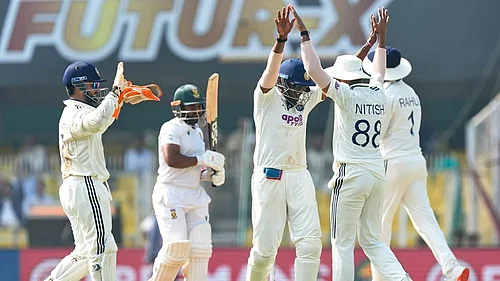 | Photo: AP/Anupam Nath : Indias players celebrate the dismissal of South Africas captain Temba Bavuma, second left, on the fourth day of the second cricket test match between India and South Africa in Guwahati.