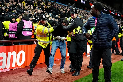 | Photo: Nick Potts/PA via AP : A Young Boys fan is escorted from the stadium by police during the Europa League soccer match between Aston Villa and Young Boys in Birmingham, England.