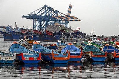 | Photo: PTI : Fishing boats remain anchored against the backdrop of Vizhinjam International Seaport in the wake of bad weather and the impact of cyclonic storm Ditwah, in Thiruvananthapuram.