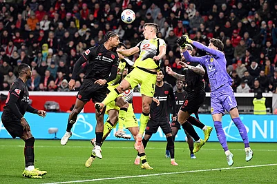 | Photo: Federico Gambarini/dpa via AP : Bayers Loïc Badé, center left, and Borussias Nico Schlotterbeck fight for the ball during the German Bundesliga soccer match between Bayer Leverkusen and Borussia Dortmund in Leverkusen, Germany.