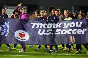 | Photo: AP/Rebecca Blackwell : United States players including goalkeeper Mandy McGlynn (1), waving, and United States midfielder Lily Yohannes, center right, carry a banner to thank fans at the end of an international friendly soccer match against Italy in Fort Lauderdale, Fla.