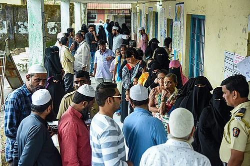 Photo: PTI : People wait in a queue to cast their votes at a polling booth during the Maharashtra local body elections, at Taloja, in Navi Mumbai.